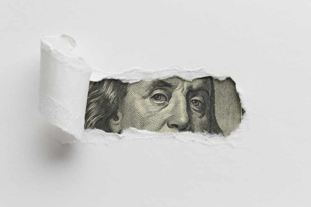 US dollar behind torn white paper